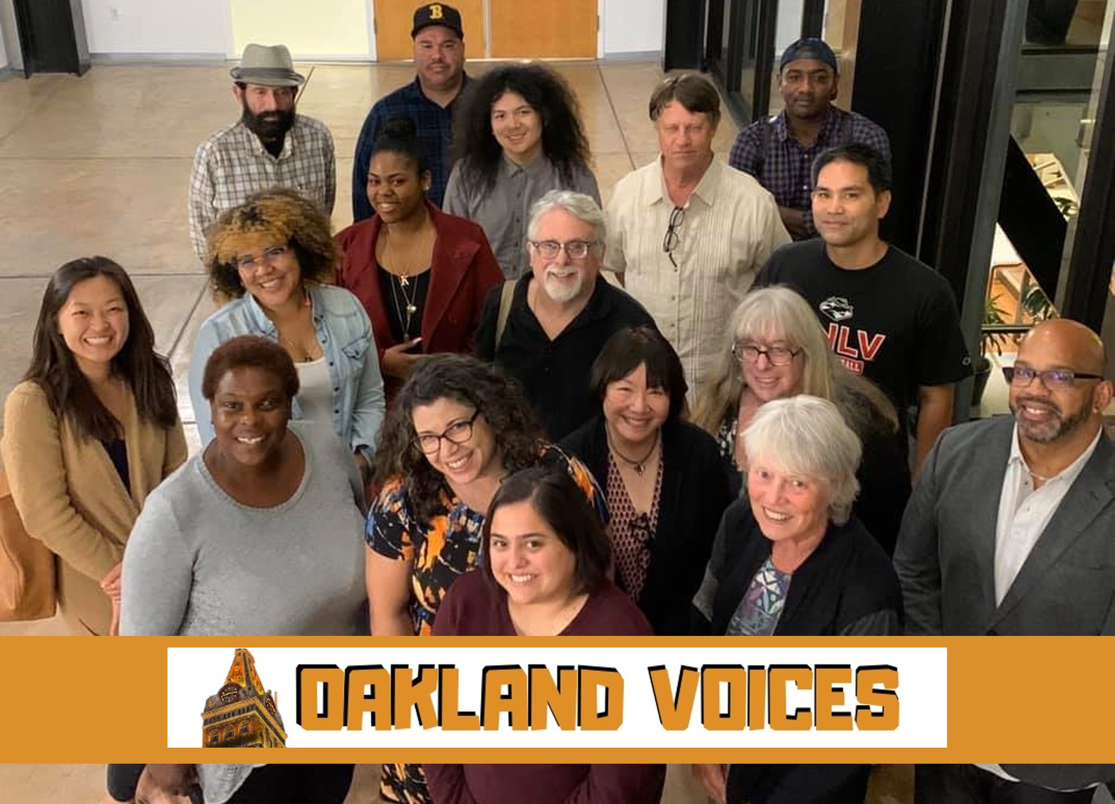 A group of about a dozen people of various ages and races looks up at a camera several feet above them. At bottom, a pumpkin-orange banner with a white rectangle. Inside the white rectangle, the top of the Tribune building and the words "Oakland Voices" in orange.