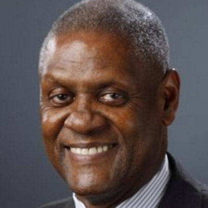 A photo of Virgil Smith, a Black man with graying hair, smiling and wearing a suit and white shirt striped with blue.