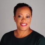 A photo of Debra Adams Simmons, a Black woman with short hair who wears a simple black blouse.